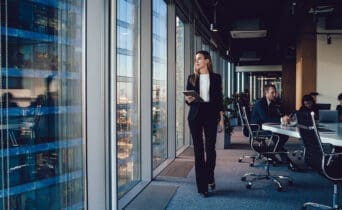 Serious female administrative manager in formal suit walking in