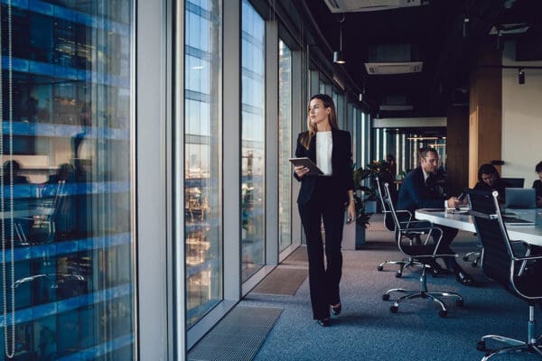 Serious female administrative manager in formal suit walking in