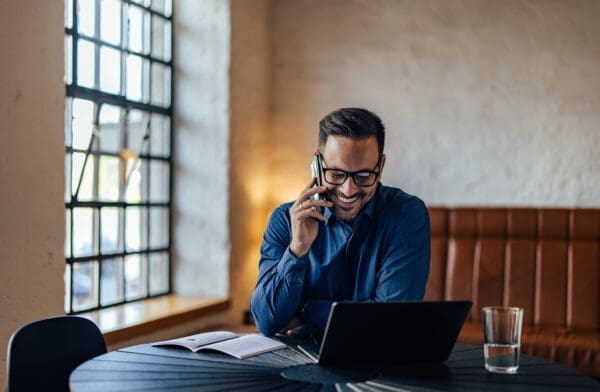 Busy man working at his office while making a phone call and smile